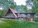 A-frame house with a deck, large windows, and a well-maintained lawn in a wooded setting at 1467 Shiloh Trail East Nw, Kennesaw, GA 30144