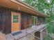 Home exterior with a wooden deck, orange door, dark siding, and natural surroundings at 1467 Shiloh Trail East Nw, Kennesaw, GA 30144