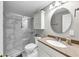 Bathroom featuring a modern shower with glass doors, a sink with granite countertop, and a storage cabinet at 1487 Monarch Ct, Marietta, GA 30062