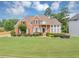 Well-maintained brick home with a spacious front lawn and mature trees at 1487 Monarch Ct, Marietta, GA 30062