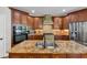 A kitchen features wood cabinets, stainless appliances, a tile backsplash, and a large island with double sinks at 1487 Monarch Ct, Marietta, GA 30062