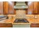 Close up of a gas stovetop with olive green vent hood, tile backsplash, and granite countertops at 1487 Monarch Ct, Marietta, GA 30062