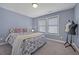 Comfortable bedroom with blue walls, patterned bedding, plush pillows, and large windows at 3735 Hazel Ave, Cumming, GA 30040