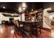 Finished basement bar area with stools, hardwood floors, and a decorative ceiling at 3820 Preserve Crossing Ln, Cumming, GA 30040