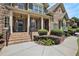 Inviting brick front porch with detailed columns and iron railing, framed by manicured bushes and walkway at 3820 Preserve Crossing Ln, Cumming, GA 30040
