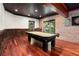Spacious game room with a pool table, brick accent wall, and decorative ceiling at 3820 Preserve Crossing Ln, Cumming, GA 30040