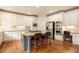 Well-lit kitchen features custom white cabinets, stainless appliances and a central island perfect for gathering at 3820 Preserve Crossing Ln, Cumming, GA 30040