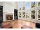 Bright living room with fireplace, custom built-ins, and large windows overlooking a lush landscape at 3820 Preserve Crossing Ln, Cumming, GA 30040