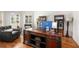 Bright home office space with large wooden desk, comfortable seating, and natural light from shuttered windows at 3820 Preserve Crossing Ln, Cumming, GA 30040