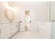 A modern bathroom features a round mirror, sleek vanity, and a luxurious freestanding tub at 550 Fisher Dr # 47, Alpharetta, GA 30009
