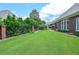 Large backyard with well-maintained lawn, brick fence, and mature landscaping at 1570 Woodberry Run Dr, Snellville, GA 30078