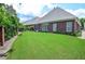 Expansive backyard with green lawn and brick perimeter wall, creating a private outdoor space at 1570 Woodberry Run Dr, Snellville, GA 30078
