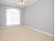 Bright bedroom with large window, neutral carpet, and classic trim at 1570 Woodberry Run Dr, Snellville, GA 30078