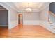 Dining room with hardwood floors, wainscoting, tray ceiling with chandelier, and stairs at 1570 Woodberry Run Dr, Snellville, GA 30078