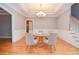 Dining room with hardwood floors, wainscoting, tray ceiling with chandelier, and stairs at 1570 Woodberry Run Dr, Snellville, GA 30078
