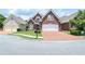 Beautiful brick home with a well-kept lawn, brick driveway, and attached two-car garage at 1570 Woodberry Run Dr, Snellville, GA 30078