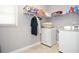Functional laundry room with appliances, storage shelves, and natural light at 1570 Woodberry Run Dr, Snellville, GA 30078