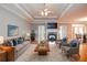 Staged living room features a cozy fireplace, plush seating, and a tray ceiling at 1570 Woodberry Run Dr, Snellville, GA 30078