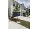 Modern townhome with white siding, a dark garage door, and landscaping at 2853 Bullfrog Ln # 172, Gainesville, GA 30115