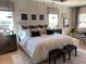 Spacious main bedroom with neutral tones, board and batten accent wall, and lots of natural light at 3010 Florence St, Cumming, GA 30041