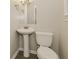 A compact bathroom featuring a pedestal sink and toilet with neutral walls and fixtures at 4631 Ben Hill Rd, Douglasville, GA 30134