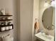 A half bathroom featuring decorative shelves, with an oval mirror above a sink at 2145 Coventry Dr, Brookhaven, GA 30319