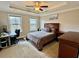 A bedroom with a tray ceiling, two windows, a large bed and workspace at 2145 Coventry Dr, Brookhaven, GA 30319