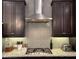 A kitchen featuring dark wood cabinets, stainless steel range hood, and a gas cooktop on granite countertops at 2145 Coventry Dr, Brookhaven, GA 30319