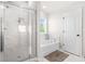 Modern bathroom with glass shower, soaking tub, and elegant white tile surround at 361 Traditions Ln, Hampton, GA 30228