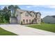 Brick and siding home with a long driveway leading to a two car garage at 361 Traditions Ln, Hampton, GA 30228