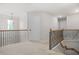 Upstairs hallway with neutral carpet, white walls, and decorative railing and lots of natural light at 361 Traditions Ln, Hampton, GA 30228