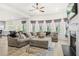 Cozy living room with a fireplace, lots of windows and a large sectional sofa with decorative pillows at 361 Traditions Ln, Hampton, GA 30228