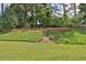 Landscaped backyard featuring a natural setting with mature trees at 5891 Buckner Creek Dr, Mableton, GA 30126