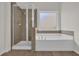 Bathroom with a shower and large tub surrounded by tile accents at 5891 Buckner Creek Dr, Mableton, GA 30126