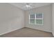 Bright bedroom features plush carpet, a ceiling fan, and a large window at 5891 Buckner Creek Dr, Mableton, GA 30126