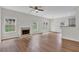 Open-concept living room with hardwood floors, fireplace, windows, and direct access to the kitchen at 5891 Buckner Creek Dr, Mableton, GA 30126
