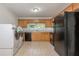 Well-lit kitchen with light cabinets, black appliances, tile flooring, and a laundry closet at 804 Brookdale Sw Dr, Atlanta, GA 30315