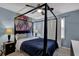 Stylish bedroom featuring a four poster bed frame, unique wall art, and soothing ambiance at 1010 San Marcos Cv, Lawrenceville, GA 30043
