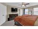 Serene bedroom featuring a ceiling fan, dresser with TV and a window allowing natural light at 1010 San Marcos Cv, Lawrenceville, GA 30043