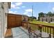 A view of a back porch with wood rails and a small outdoor seating area with community views beyond at 114 Brackley Dr, Cumming, GA 30040