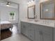 A bathroom with a double sink vanity, stone countertops, and framed mirrors next to the primary bedroom at 114 Brackley Dr, Cumming, GA 30040