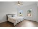 A primary bedroom with hardwood floors, a ceiling fan, and two windows allowing for natural light at 114 Brackley Dr, Cumming, GA 30040