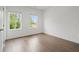 Bright bedroom with wood floors, two windows overlooking the outside, and white trim at 114 Brackley Dr, Cumming, GA 30040