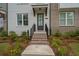 Inviting townhome entrance with landscaped garden and brick walkway at 114 Brackley Dr, Cumming, GA 30040