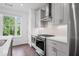 A kitchen with stainless steel appliances, grey cabinets, stone countertops and tile backsplash under a window at 114 Brackley Dr, Cumming, GA 30040
