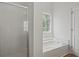 Bathroom features a shower, bathtub, and window for natural light at 1910 Towne Park Dr, Mcdonough, GA 30252