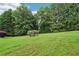 Grassy backyard showing a few bushes and green trees at 4508 Meadow Vista Trce, Lithonia, GA 30038