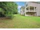 Sloped backyard showing brick and siding home exterior, deck, and trees at 4508 Meadow Vista Trce, Lithonia, GA 30038