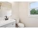 Clean bathroom featuring modern vanity, toilet, and window at 4508 Meadow Vista Trce, Lithonia, GA 30038