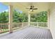 Open-air deck showing ceiling fan, wooden floors and railing overlooking the backyard trees at 4508 Meadow Vista Trce, Lithonia, GA 30038